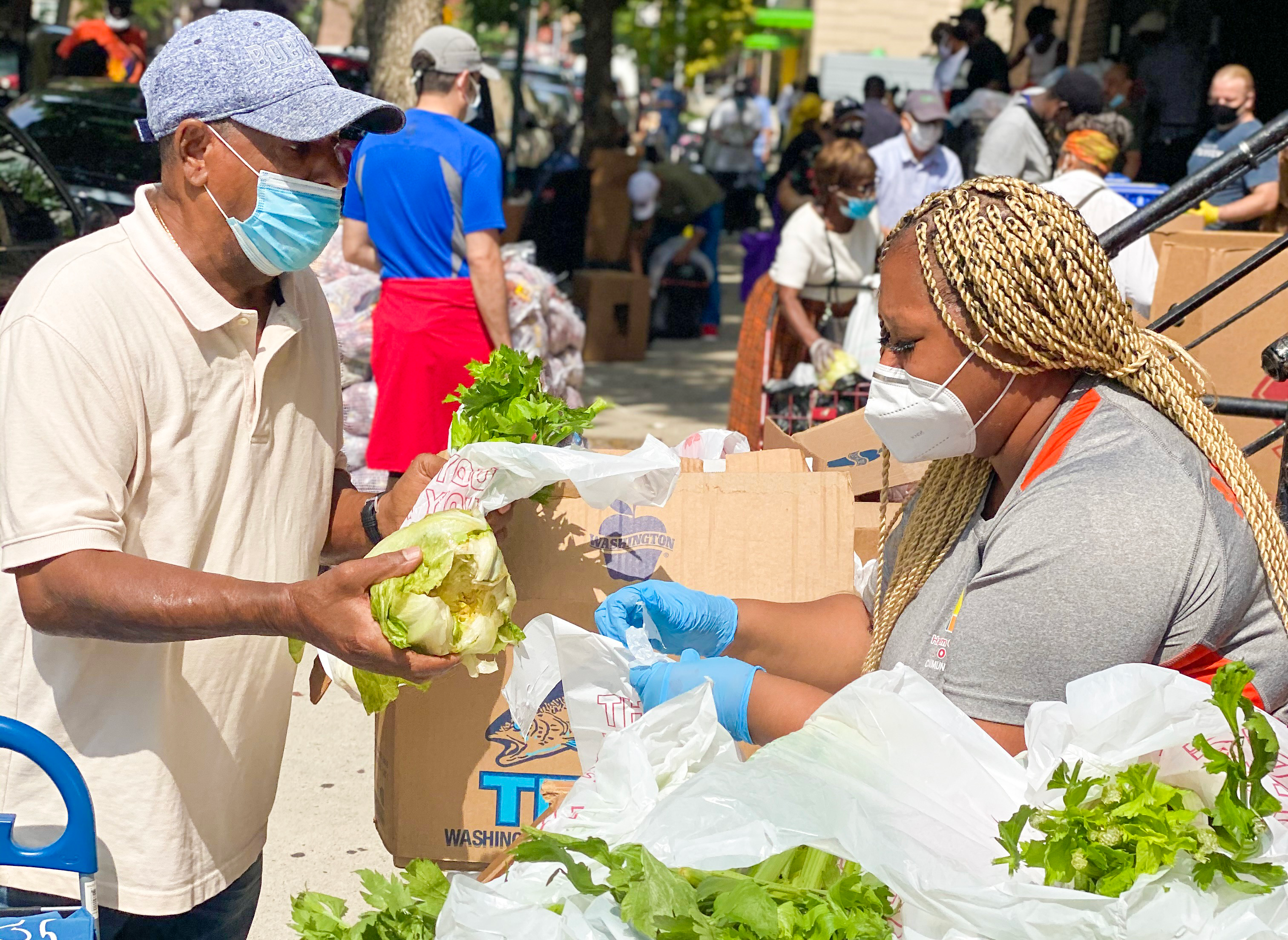 A man and woman exchange produce at a farmers market