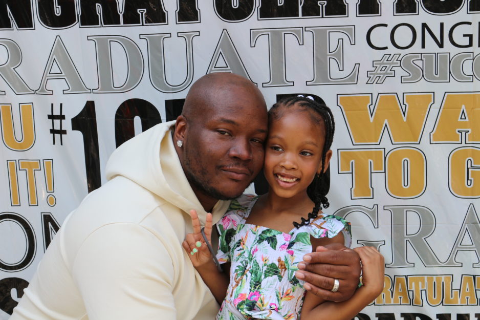 A Gems scholar and her father smile at her graduation ceremonny during Harlem Children's Zone Graduation Week 2022