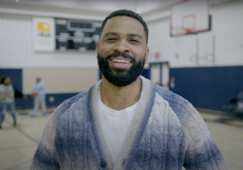 Deondre Coston smiles in a gymnasium.