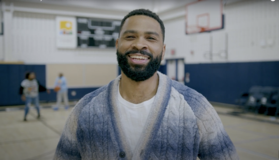 Deondre Coston smiles in a gymnasium.