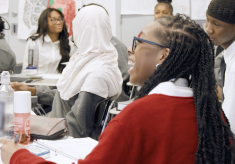 Shania Sanders laughs, facing away from the camera, in a classroom.