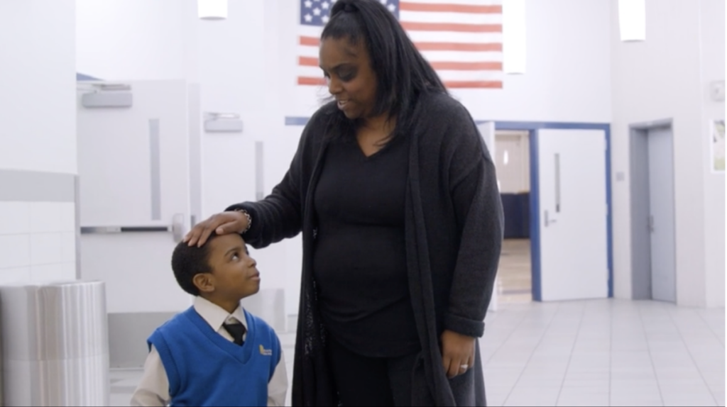 DeniLee pats her son Reginald on the head in a school hallway.