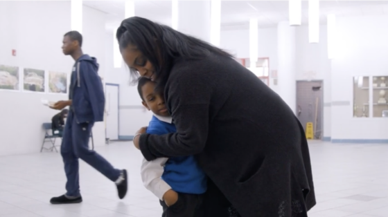 A mother, DeniLee Peroza, hugs her son Reginald in a school hallway.